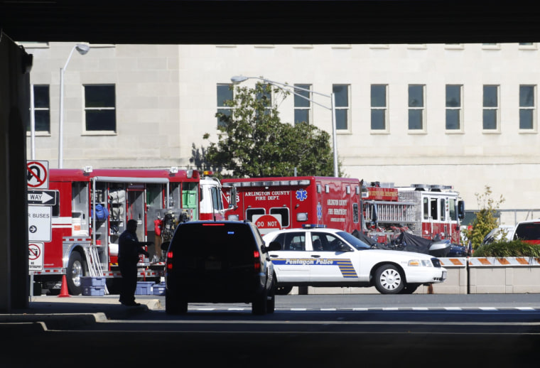 Image: Emergency workers work in a closed-off Pentagon parking lot where a woman who recently traveled to Africa vomited, in Washington