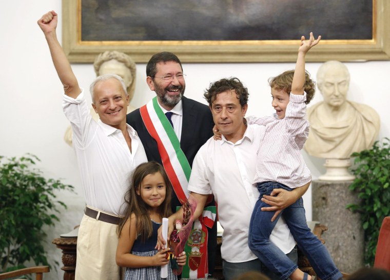 Image: A gay couple, officially married outside Italy, pose with Rome's mayor Marino during a ceremony for the registration of their marriage in Rome