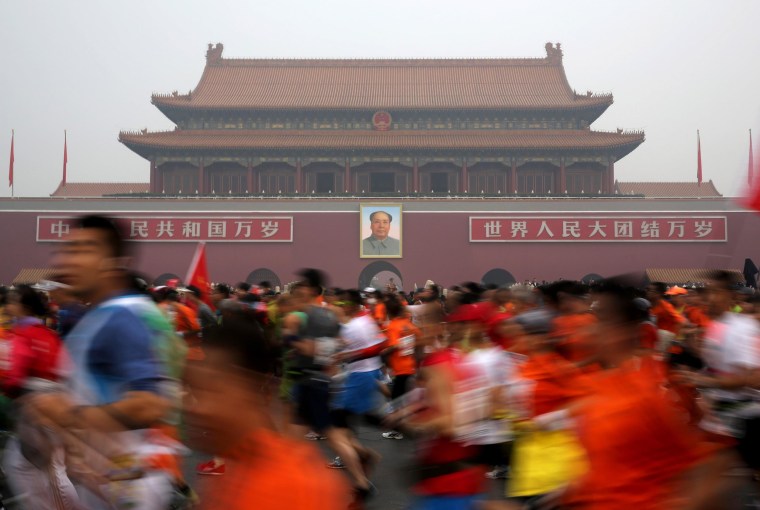 Image: Runners jog past Tiananmen Gate shrouded in haze