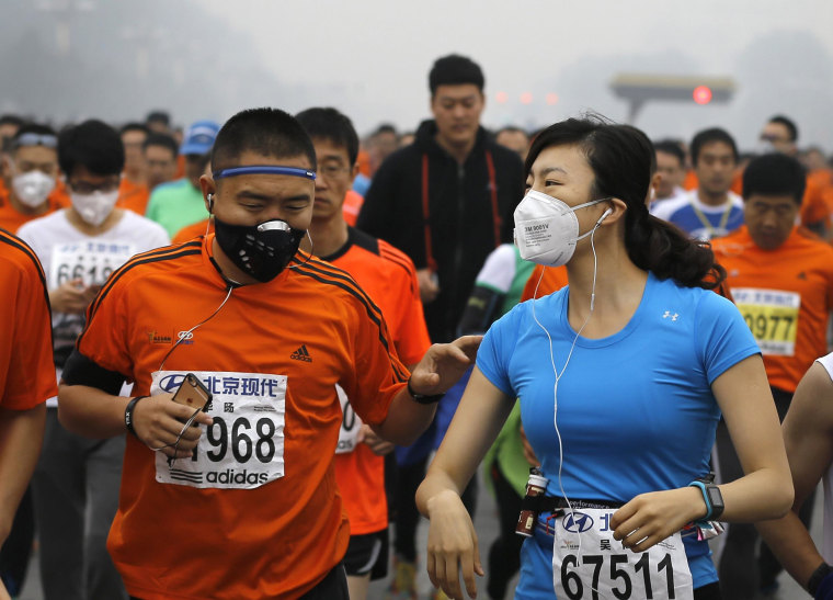 Image: Runners jog past Tiananmen Gate shrouded in haze