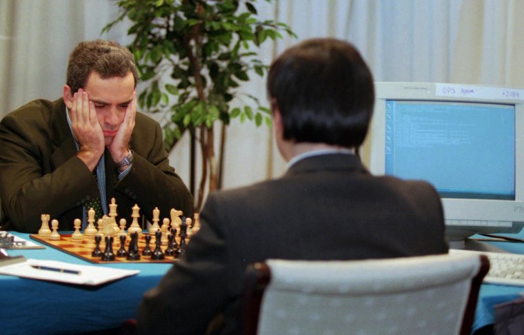 Man playing chess against computer Stock Photo