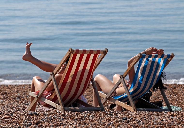 Image: People enjoy the sunshine on a beach.