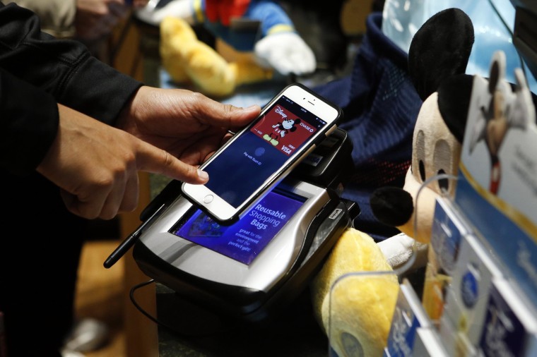 A customer makes a purchase at the Disney Store in Times Square using Apple Pay.
