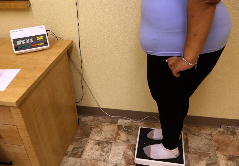 Image: Overweight woman stands on a scale