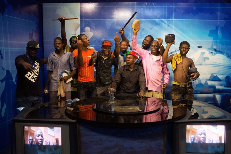 Image: Anti-government protesters take over the state TV podium in Ouagadougou
