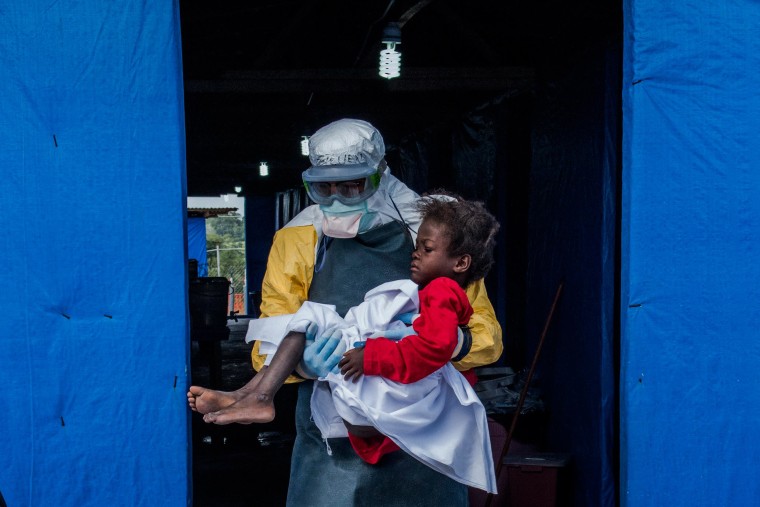 Image: Dr. Steven Hatch carries Blessing Gea, 9, from the suspected ward to the confirmed high-risk ward after a blood test showed her positive for Ebola, at a clinic run by the International Medical Corps.