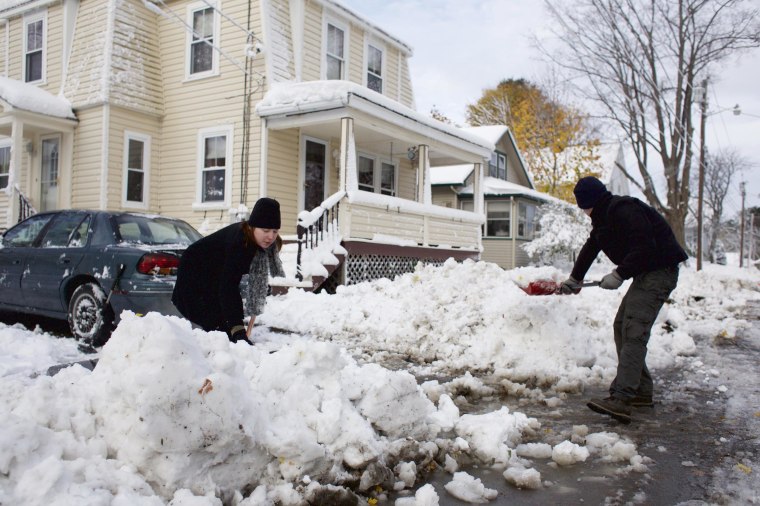 Image: Candice and Andre Schoth shovel away a snow pile from plowing at the end of their driveway on Dean Street in Bangor