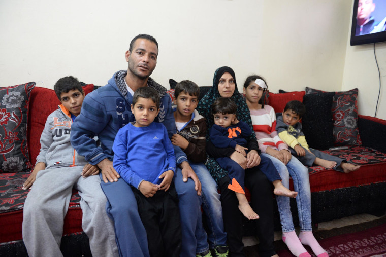 Fatimah Kayed Al-Rajabi, second right, sits with her parents and siblings inside their house in Silwan.