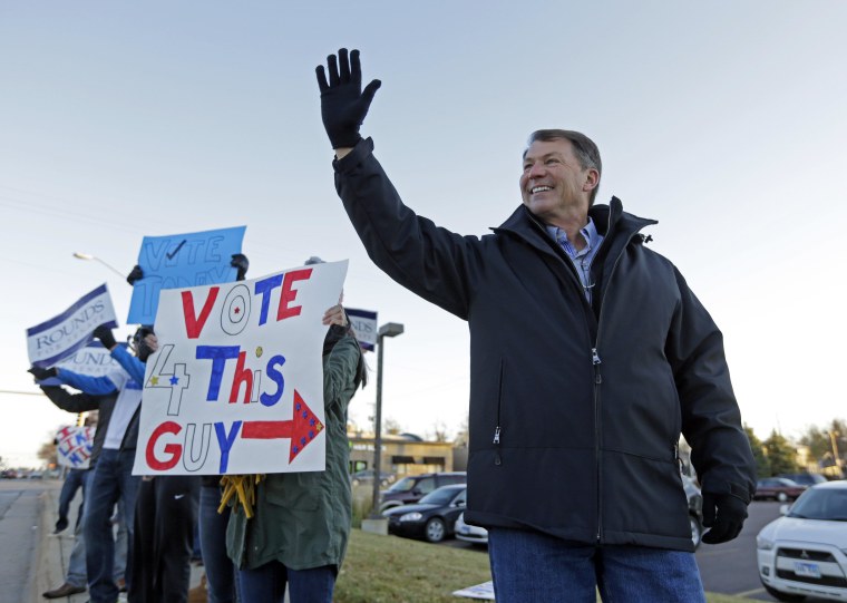 Republican U.S. Senate candidate Mike Rounds campaigns with supporters during the morning commute in Sioux Falls, S.D., Tuesday, Nov. 4, 2014. Rounds, former South Dakota governor, faces Democrat Rick Weiland and Independents Gordon Howie and Larry Pressler. (AP Photo/Michael Conroy)