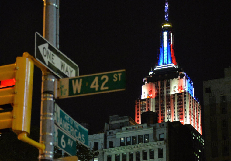 Image: Blue and red colors illuminate the Empire State Building, showing the preliminary polling results of the Senate race earlier in the evening.