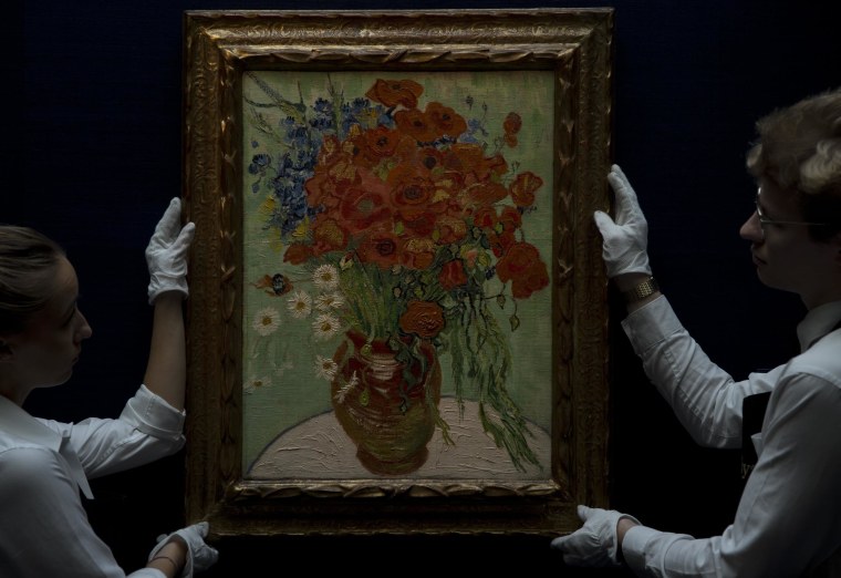 Sotheby's employees stand next to painting by Vincent Van Gogh, said to be on of his last, entitled 'Still Life- Vase with Daisies and Poppies' 1890.