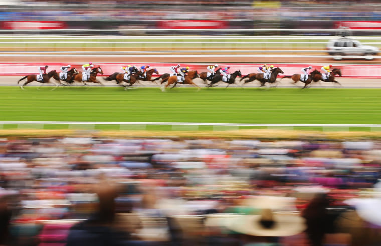 Image: The field goes along the straight in the Visit Victoria Plate on Melbourne Cup Day