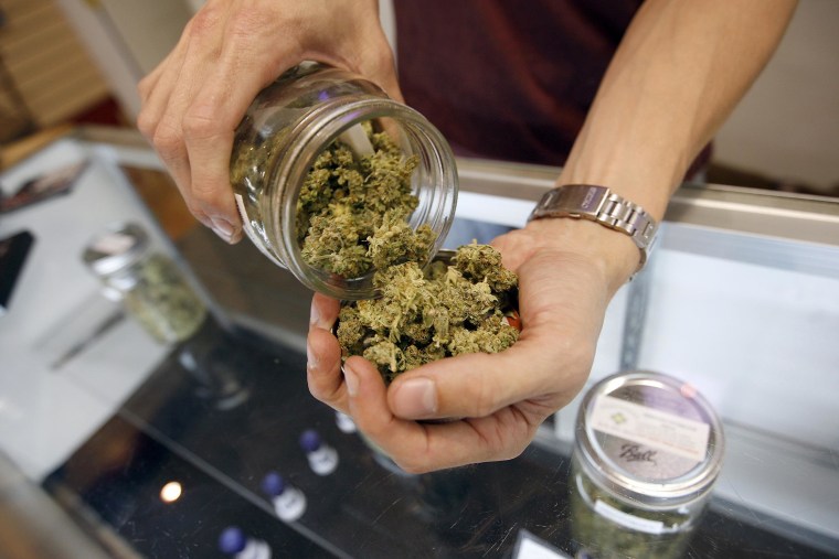 A budtender pours marijuana from a jar at Perennial Holistic Wellness Center medical marijuana dispensary in Los Angeles, California. 
