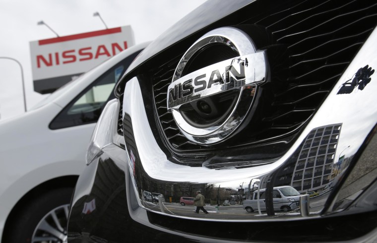 A pedestrian is reflected in a Nissan Motor car at the company's dealership in Tokyo