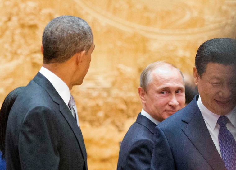 Image: Putin looks back at Obama as they arrive with Xi Jinping at APEC Summit plenary session in Beijing