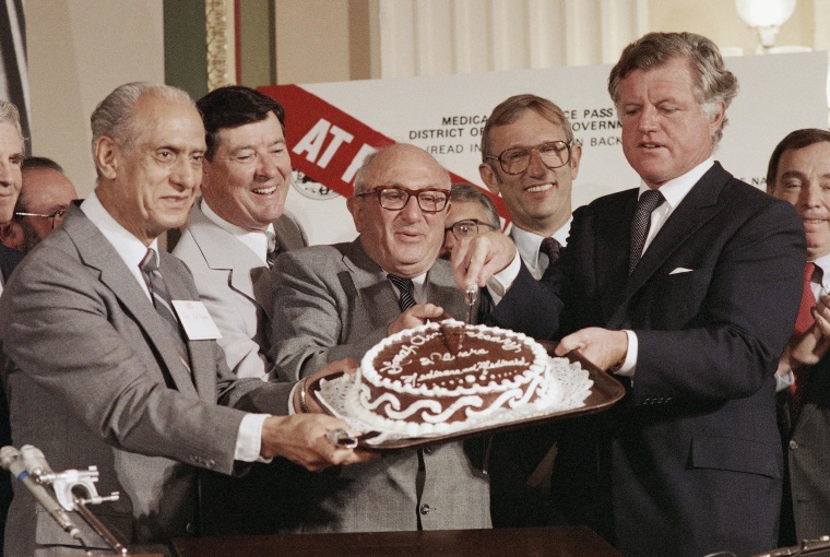 File photo of former California Democratic Congressman Edward Roybal, at left, with the late Senator Edward M. Kennedy and other legislators at the 20-year birthday party celebration for Medicaid and Medicare, July 30, 1985.  At the time Roybal was Chairman of the House Select Committee on Aging.