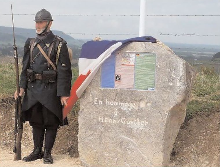 A man in WWI-era French uniform stands beside a memorial stone on the very spot where Henry Gunther fell on Nov. 11, 1918. The stone was unveiled by the French government as part of a 90th anniversary event in 2008.