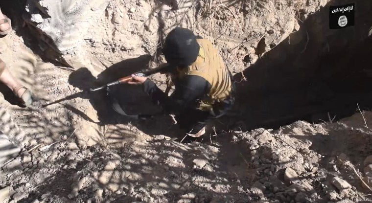 Image: ISIS fighters sit in a cave.