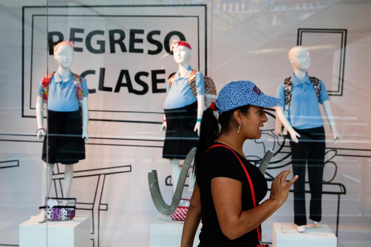 A woman reacts in front of a display showing mannequins of pregnant schoolgirls at a shopping mall in Caracas on Nov. 12.