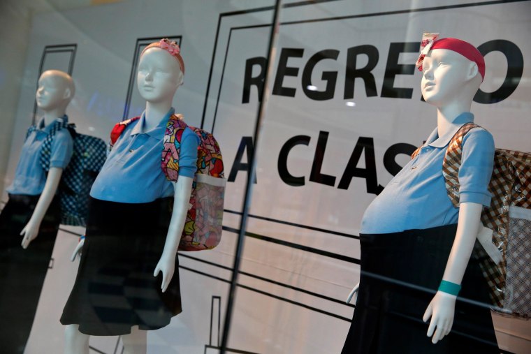 Image: Mannequins of pregnant schoolgirls are seen in a shop window at a shopping mall in Caracas