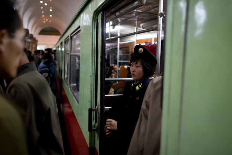 A conductor stands inside a train at Puh