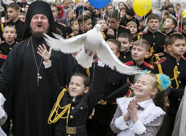Image: A young military cadet releases a pigeon after an oath-taking ceremony at the Kiev Pechersk Lavra monastery in Kiev