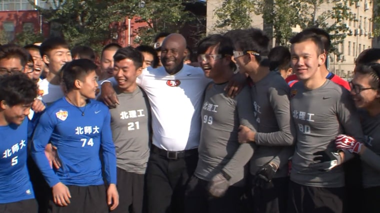 Jerry Rice poses with aspiring football players after a practice session in Beijing.