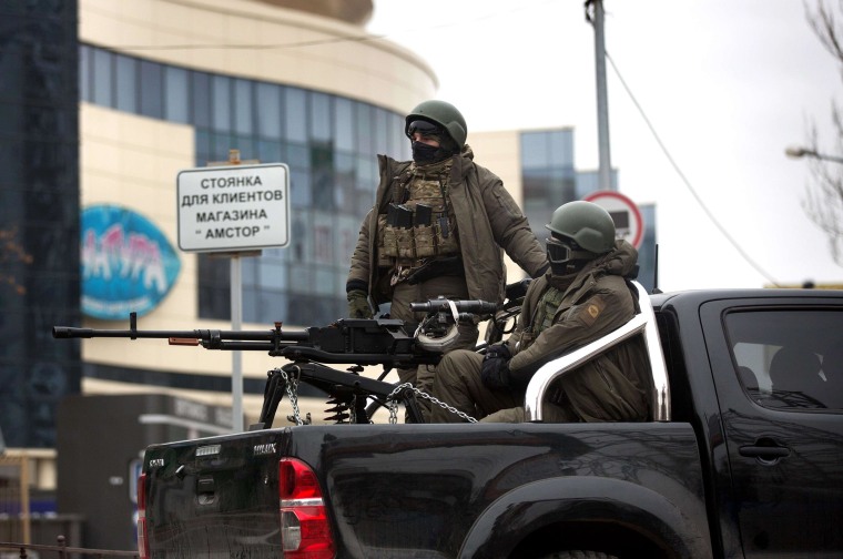 Image: Pro-Russian gunmen sit in the back of a vehicle mounted with a machine gun in the center of the eastern Ukrainian city of Donetsk