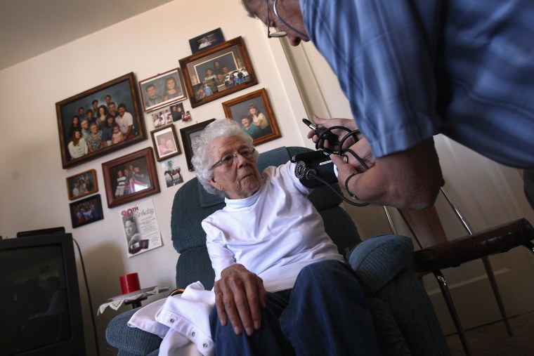 File photo of registered nurse Steve Van Dyke checking the blood pressure of Pauline Zocholl, 94, while on a home health care visit on March 23, 2012 in Westminster, Colorado. 