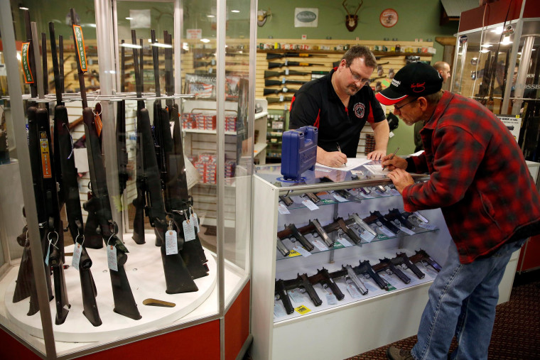 Image: Steven King, left, fills out paperwork at Metro Shooting Supplies in Bridgeton, Mo.e