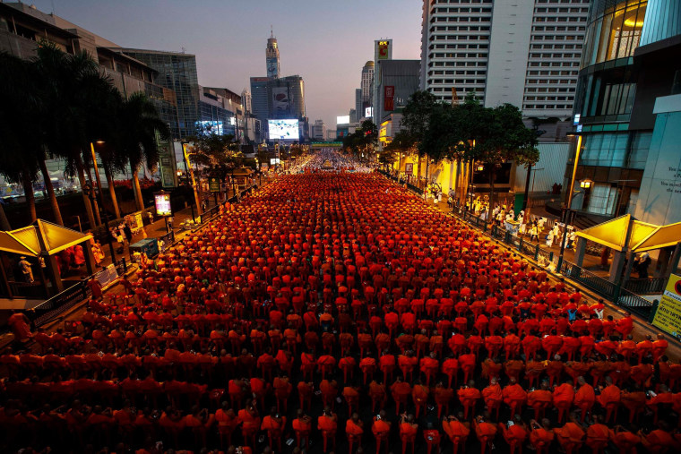 Image: Thousands of Buddhist monks attend a mass alms-offering ceremony in Bangkok's shopping district