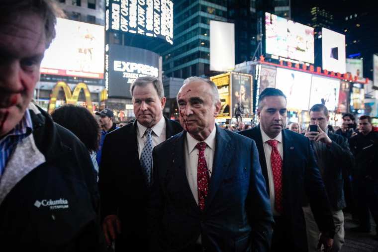 A protester threw fake blood on NYPD Commissioner Bill Bratton during a demonstration over the death of Michael Brown in New York's Times Square on Monday night.