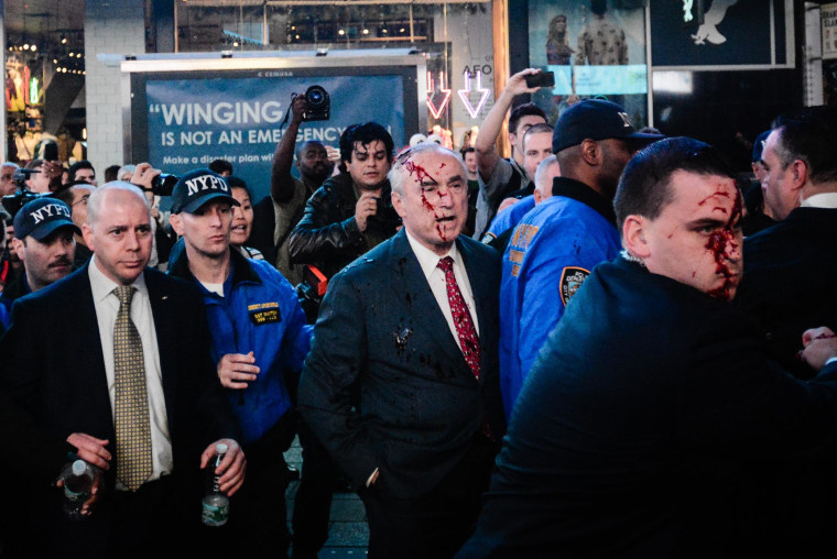 A protester threw fake blood on NYPD Commissioner Bill Bratton during a demonstration over the death of Michael Brown in New York's Times Square on Monday night.