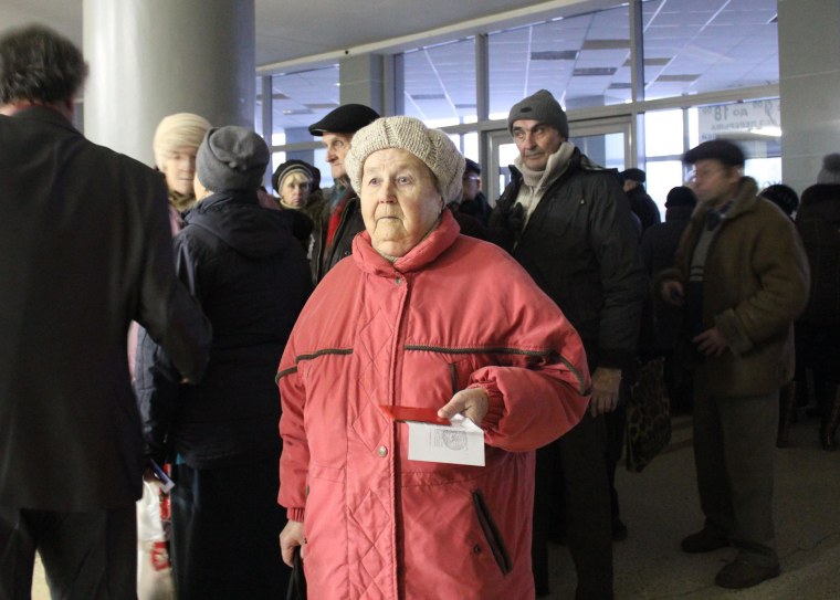 Tamara waits in line to receive a food donation at a former circus in the city of Donetsk