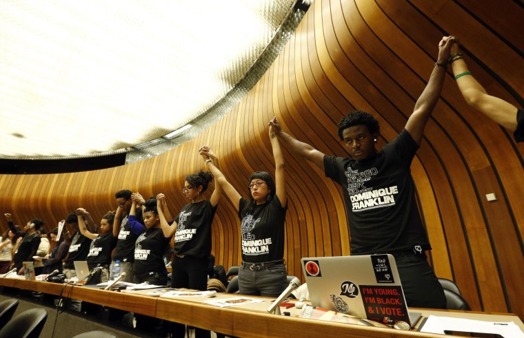 Image: Activists hold hands during a silent protest at a hearing of the United States at the Committee against Torture at the United Nations in Geneva