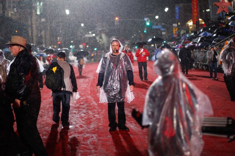 Image: Rain falls on production crew members preparing to start the 83rd Annual Hollywood Christmas Parade