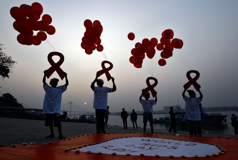Image: Children display ribbon cut-outs tied to balloons during an HIV/AIDS awareness campaign to mark World AIDS Day in Kolkata