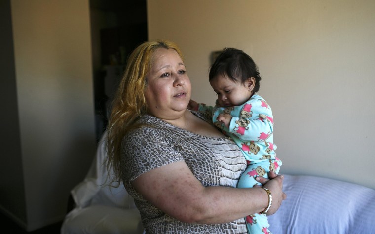 Image: Maria Guerrero holds her 14-month-old daughter