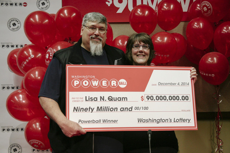 Image: Lisa Quam and her husband hold a check for $90 million during a news conference in Olympia, Washington