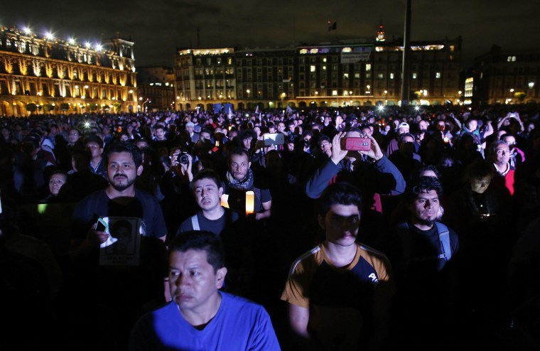 Image: Demonstrators listen to a speech delivered by the father of one of the 43 missing students of the Ayotzinapa teachers' training college, during a protest at Zocalo square in Mexico City