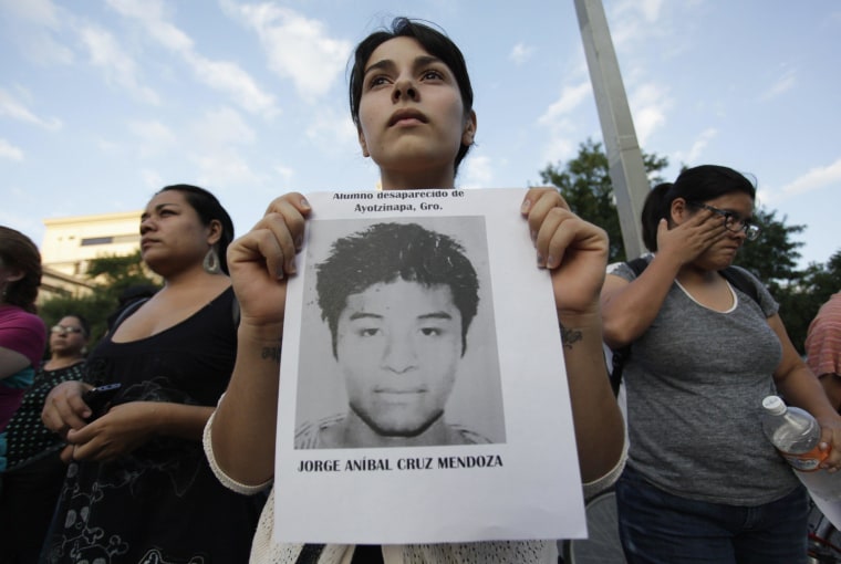 A woman holds a photograph of a missing student during a march in support of the Ayotzinapa Teacher Training College missing students, in Monterrey October 8, 2014. 