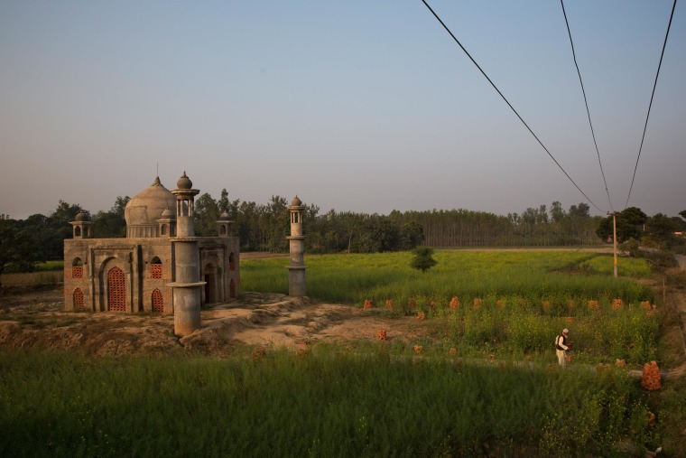 Image: Retired postman Faizul Hassan Qadri, 79, walks out of the monument he is building for his late wife Tajammuli