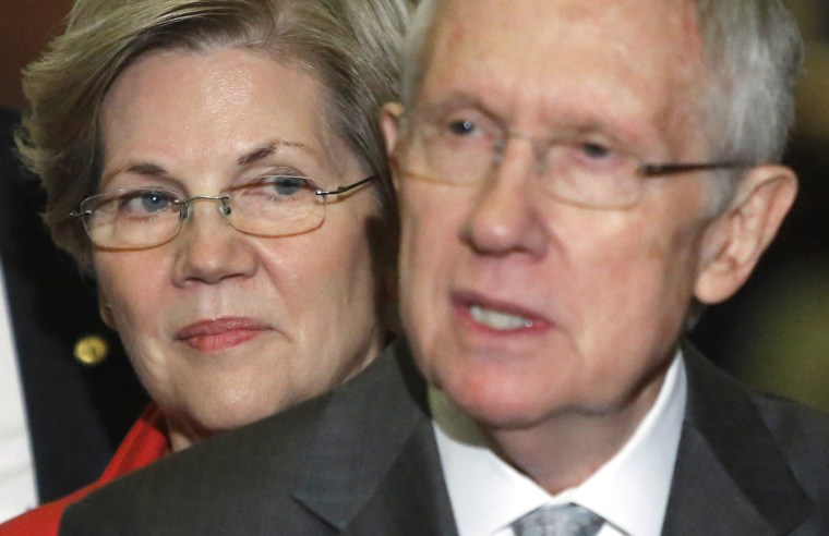 Image: U.S. Senator Warren stands behind Senate Majority Leader Reid after leadership elections for the Congress in Washington