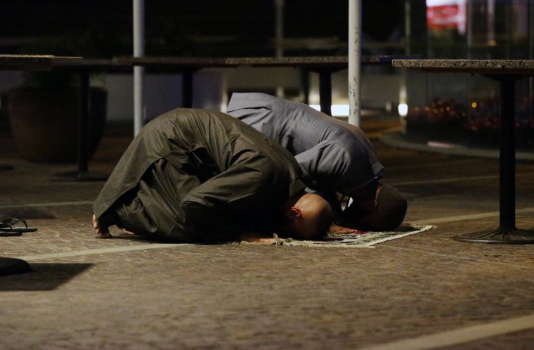 Image: Sam Tiger right, and Abdulrahman El-Lawn perform prayers