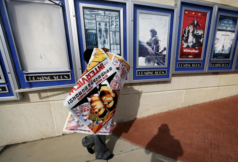 A poster for the movie "The Interview" is carried away by a worker after being pulled from a display case at a Carmike Cinemas movie theater, on Dec. 17, 2014 in Atlanta. Georgia-based Carmike Cinemas has decided to cancel its planned showings of "The Interview" in the wake of threats against theatergoers by the Sony hackers.