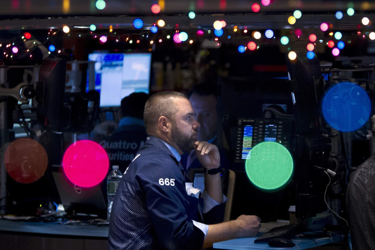Image: Trader Kevin Lodewick works on the floor of the NYSE, which has been decorated with Christmas lights, in New York