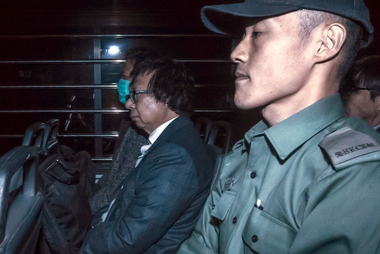 Image: Francis Kwan and Thomas Kwok sit in a prison van as they leave the High Court in Hong Kong