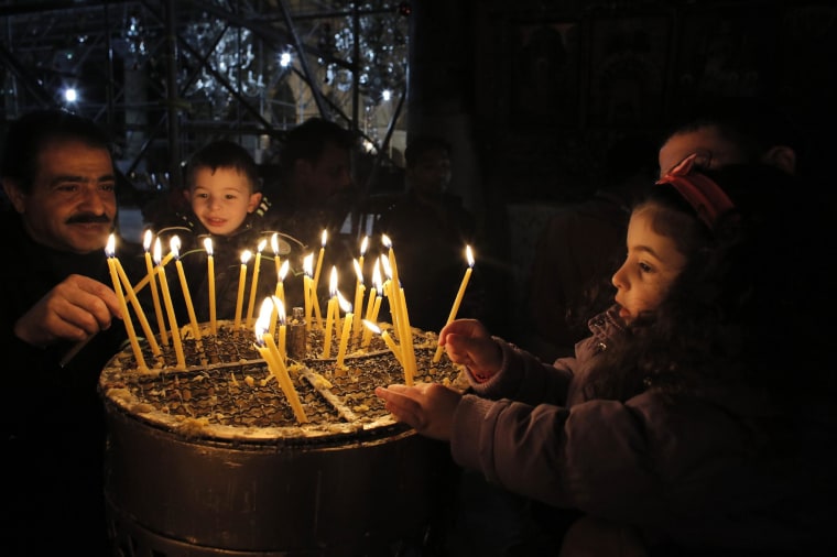 Image: Visitors light candles in the Church of the Nativity, the site revered by Christians as Jesus' birthplace, ahead of Christmas in Bethlehem,  West Bank