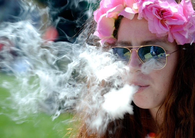 A woman smokes marijuana during the 4/20 Rally at the Civic Center in Denver