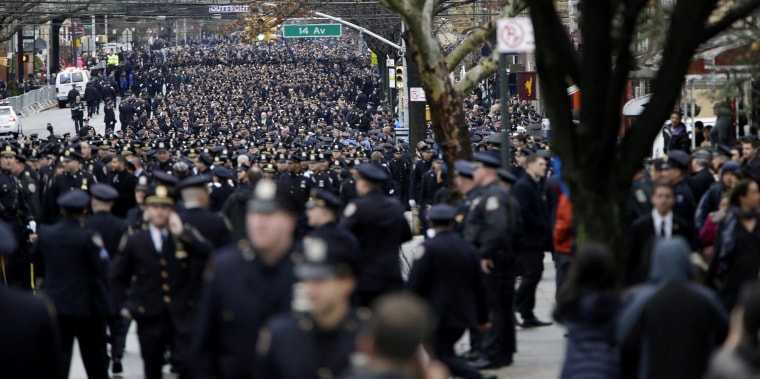 Image: Police officers line the streets before the funeral of Officer Wenjian Liu in the Brooklyn borough of New York, Sunday, Jan. 4. Liu and his partner, officer Rafael Ramos, were killed Dec. 20 as they sat in their patrol car on a Brooklyn stree